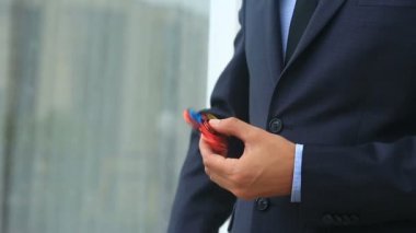 Çok renkli, Kırmızı-Sarı-Mavi el spinner veya üzerinde dönen fidgeting spinner el mans. Sokakta topluca spinner iplik elbiseli adam