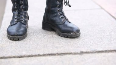 Yoldan geçenler tarafından bir kalabalık içinde Sokak ortasında bir adam bağlama üzerinde yırtık, lime lime Çizmeli standları.