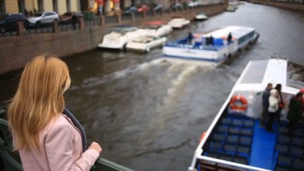 Eine Frau im Mantel steht auf einer Brücke und blickt auf das schwarze Wasser herab. Sie will Selbstmord begehen — Stockvideo