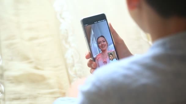 Niño adolescente sostiene un video chat con una mujer en un teléfono inteligente — Vídeos de Stock