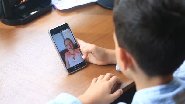 Garçon adolescent tient un chat vidéo avec une femme sur un smartphone — Video