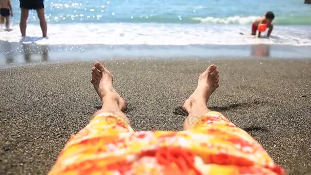 Láb a férfiak a strandon mellett a surf vonal, kilátással a tengerre — Stock videók