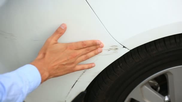 Regardant un véhicule endommagé. homme inspecte les dommages à la voiture après un accident — Video