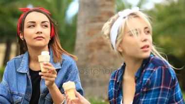 Şehir Park'ın bahçesinde oturan ve dondurma yemek iki neşeli kız arkadaşım