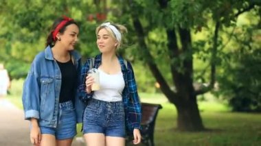 İki kız arkadaşım şehri sokak yürüyüş yapın ve bir milkshake tek kullanımlık bir bardak içki