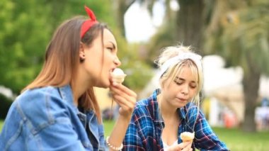 Şehir Park'ın bahçesinde oturan ve dondurma yemek iki neşeli kız arkadaşım