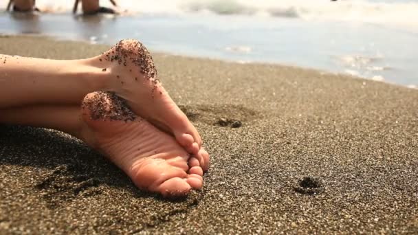 Жінки-ноги на пляжі поруч з лінією серфінгу, вид на море — стокове відео