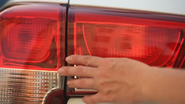 Regardant un véhicule endommagé. Une personne vérifie les dommages aux phares de la voiture après un accident. gros plan — Video
