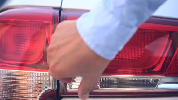 Keresek egy sérült jármű. Egy személy ellenőrzi a kár, hogy az autó fényszórói, egy baleset után. közeli kép: — Stock videók