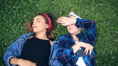 Selfie telefonda Şehir Parkı yeşil glade üzerinde oturan iki neşeli şirin kız arkadaşım var