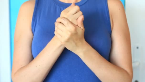 Woman is creaming her hands for soft skincare. A woman smears her hands with a hand cream on the background of her breast. — Stock Video