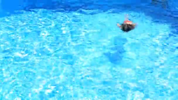 El niño está nadando en el agua azul de la piscina. vista desde arriba . — Vídeos de Stock