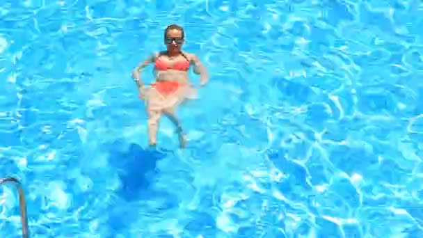 Blonde hübsche Frau genießt das Wasser im Pool. Blick von oben — Stockvideo