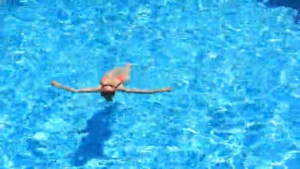 Ξανθιά όμορφη γυναίκα απολαμβάνοντας το νερό στην πισίνα. Θέα από ψηλά — Αρχείο Βίντεο