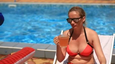 Sarhoş göbekli kadın bikini ve havuz kenarında bira içme güneş gözlüğü