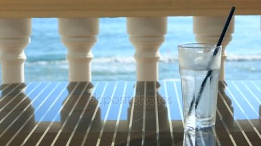 bardak su buz Deniz Manzaralı Restoran tablosundaki ile. Dalgalar deniz arka planı. kopya alanı.