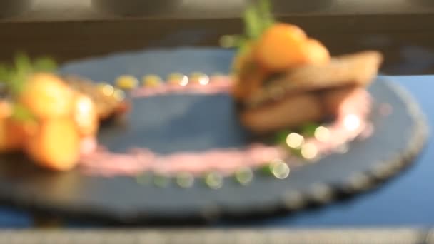 Een schotel van haute cuisine. Close-up. Vissen met jonge aardappels. Mullet. Met een glas witte wijn. Primorsik restaurant met het oog op de zee. — Stockvideo