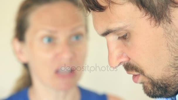 Женщина кричит на мужчину. Лицо мужчины в профиль крупным планом, лицо женщины размыто . — стоковое видео