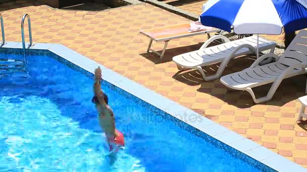 El niño está nadando en el agua azul de la piscina. vista desde arriba . — Vídeos de Stock