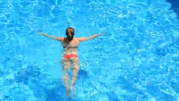 Ξανθιά όμορφη γυναίκα απολαμβάνοντας το νερό στην πισίνα. Θέα από ψηλά — Αρχείο Βίντεο