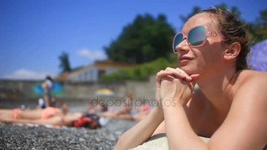 Taşlar hakkında yalan plajda güneşlenirken kadın