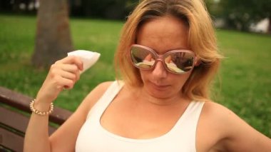 kadın bir şehir parkta bir bankta oturur ve sıcaktan bitkin.