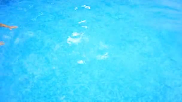 Człowiek pływa pod wodą w basenie z błękitną wodą. od góry. — Wideo stockowe