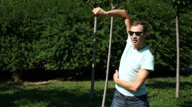 Modern bale ve wacking bir yaz Park'ta dans genç mutlu adam. uyuşuk
