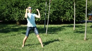 Modern bale ve wacking bir yaz Park'ta dans genç mutlu adam. uyuşuk