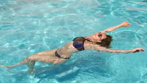 プールで水を楽しむ金髪きれいな女性。上からの眺め。スローモーション . — ストック動画