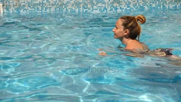 Mujer guapa rubia disfrutando del agua en la piscina. Vista desde arriba. Movimiento lento  . — Vídeo de stock