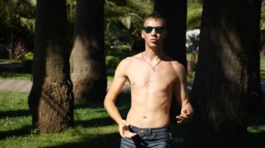 Genç, mutlu bir erkek çıplak bir gövde modern bale ve wacking bir yaz Park'ta dans ile. uyuşuk