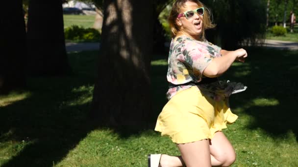 Μια νεαρή κοπέλα χαρούμενος χορός σύγχρονου μπαλέτου και wacking σε ένα πάρκο του καλοκαιριού. αργή-mo — Αρχείο Βίντεο
