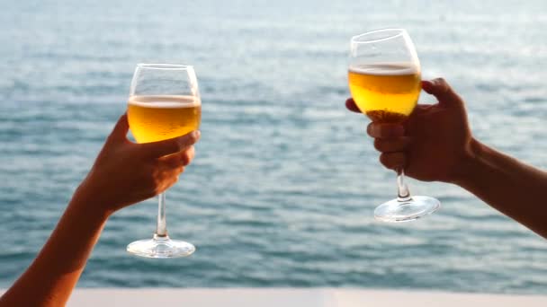 Dva lidé clink brýle s alkoholem na pozadí moře. Detail, pomalý pohyb — Stock video