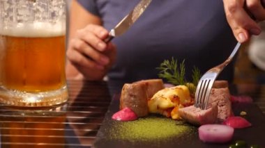 Sahil Restoran. Bir kadın et yiyor ve bir restoranda bira içiyor. Ağır çekim. yakın çekim
