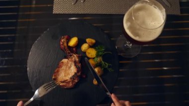 Sahil Restoran. Bir kadın et yiyor ve bir restoranda bira içiyor. Ağır çekim. yakın çekim