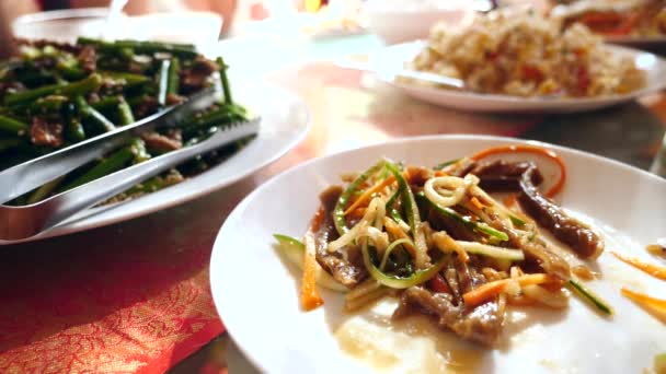 As pessoas comem comida chinesa num restaurante chinês. close-up. Movimento lento — Vídeo de Stock