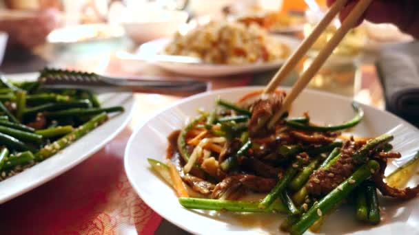 La gente come comida china en un restaurante chino. Primer plano. Movimiento lento — Vídeo de stock