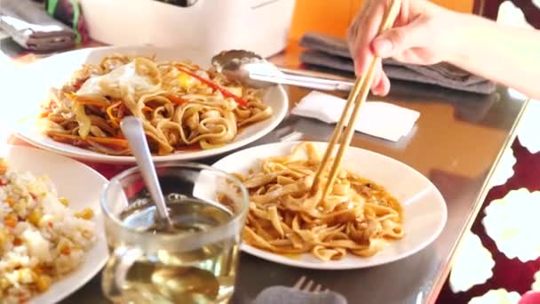 As pessoas comem comida chinesa num restaurante chinês. close-up. Movimento lento — Vídeo de Stock