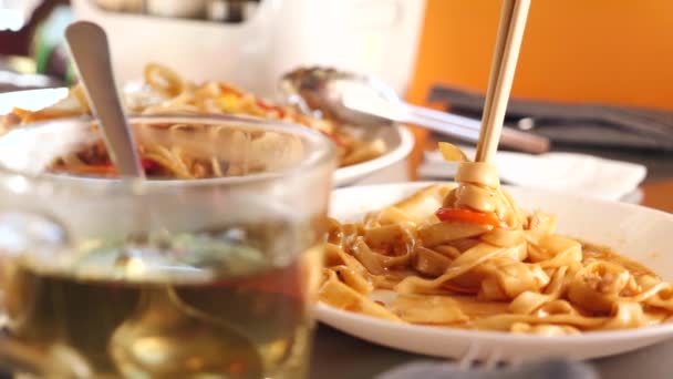 La gente come comida china en un restaurante chino. Primer plano. Movimiento lento — Vídeo de stock