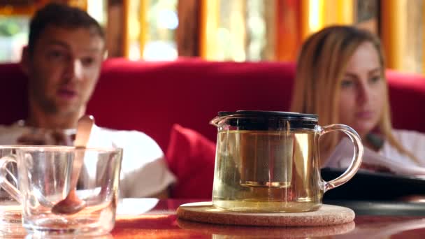 A couple is drinking tea and watching the menu in a Chinese restaurant. Slow motion — Stock Video