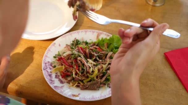 Alguien come ensalada de carne con un tenedor y un cuchillo. Primer plano. Movimiento lento . — Vídeo de stock