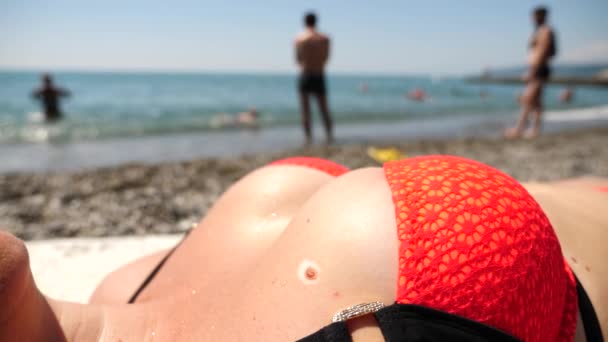 Close-up van een vrouwelijke borst op een strand in een zwembroek. Tan rond het molletje. langzame beweging, close up van Mol op de menselijke huid. grote moedervlek. — Stockvideo