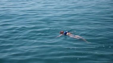 Sarışın güzel kadının açık deniz, suda yüzen. Yukarıdan görüntüleyin. Ağır çekim.