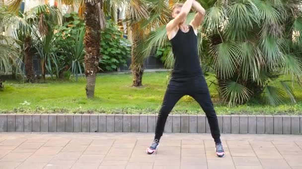 Un jeune homme heureux dansant le ballet moderne et se baladant dans un parc d'été. ralenti — Video