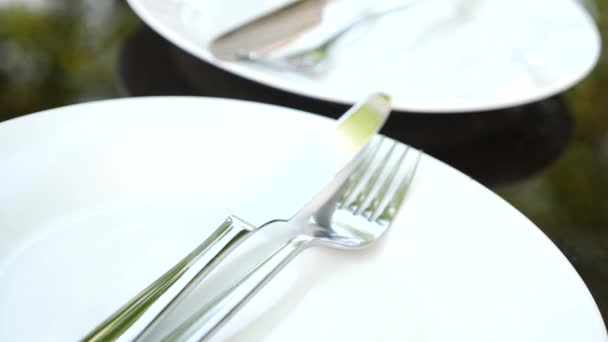 Empty white plate and cutlery on it. fork and knife. slow motion — Stock Video