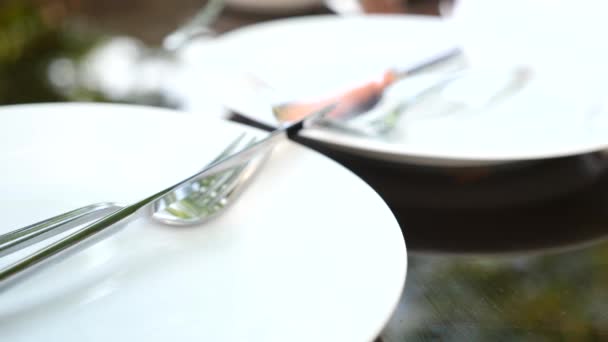 Assiette blanche vide et couverts dessus. fourchette et couteau. au ralenti — Video