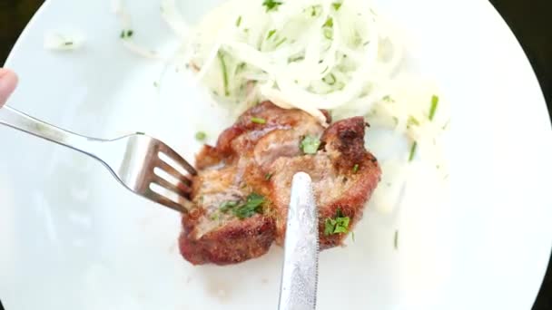 L'uomo con un coltello taglia la bistecca su un piatto in un ristorante, primo piano, 4k, rallentatore — Video Stock