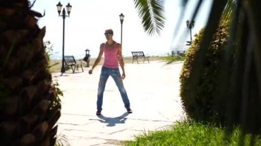 Sahildeki deniz arka plan üzerinde modern bale ve wacking dans genç mutlu adam. Uyuşuk