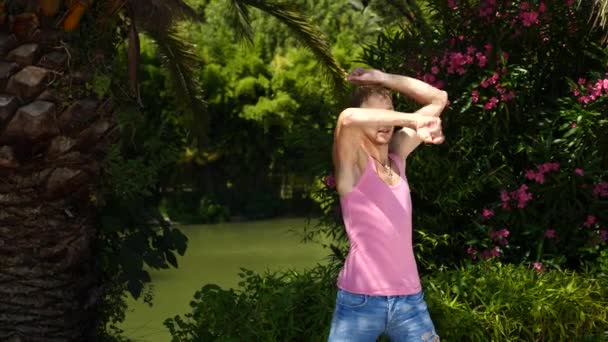 Un joven feliz bailando ballet moderno y masturbándose en un parque de verano. lento-mo — Vídeo de stock
